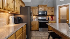 A kitchen with wooden cabinets, a stainless steel refrigerator, a microwave, an oven, and a coffee maker. - Lakeview Home in serene setting, 3 mi to Grove! Perfect for families & fishermen (Grove)