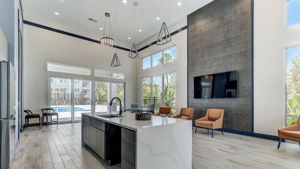 A modern kitchen with a large island, built-in appliances, and a dining area with chairs.
