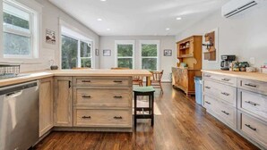 Una cocina moderna con armarios de madera, una isla central y un lavavajillas.
