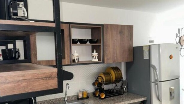 A kitchen with a built-in oven, a sink, and wooden cabinets. - Cozy 3-bedroom condo in enchanting Santa Rosa de Cabal with WiFi (Santa Rosa de Cabal)