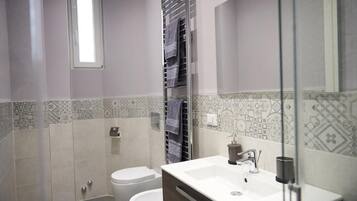 A bathroom with a toilet, a sink, and a towel rack.
