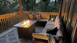 A deck with a fire feature, seating, and lanterns.
