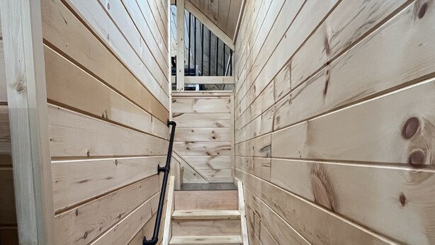 A narrow wooden staircase with a handrail, leading to a higher level. - Lillie's Pad -Cozy 2-bedroom cabin- 20 miles from Natural Bridge in Beattyville. (Beattyville)