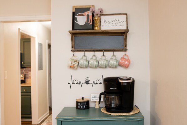 Un coin café équipé d’une machine Keurig, de tasses à café et d’une pancarte sur laquelle on peut lire : « Bienvenue au coin café. »