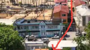 Una zona costanera amb edificis, una platja i palmeres.