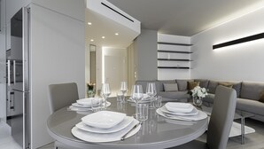 Un comedor moderno con una mesa redonda dispuesta para cuatro personas, rodeada de sillas.