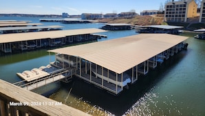 A marina with multiple docked boats and a large building in the background.