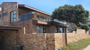A two-story house with a brick exterior, a garage, and a tree in the yard. - 87 Sand Street - Buffels bay (Buffels Bay)