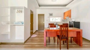 Een moderne keuken met houten kasten, een eettafel met stoelen en een inbouwoven.