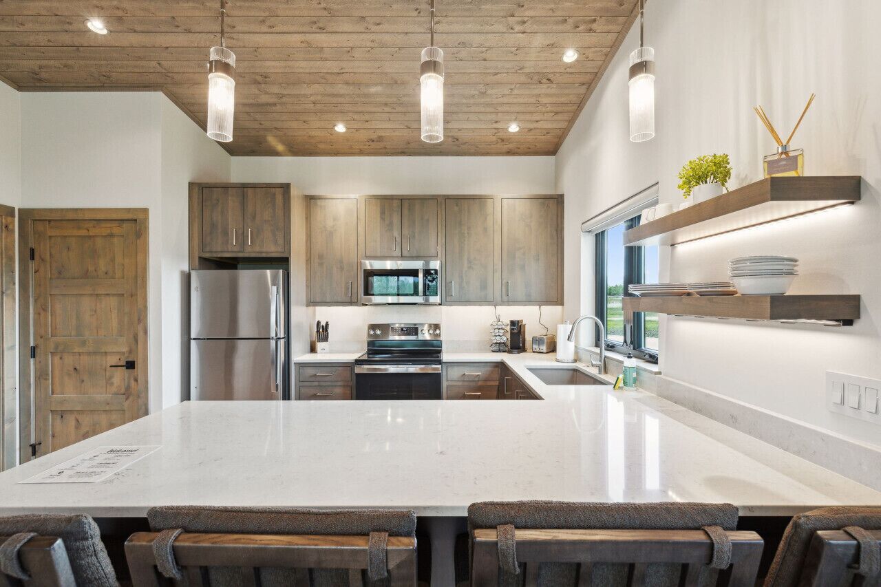 A modern kitchen with wooden cabinets, stainless steel appliances, and a large island.