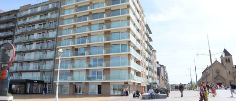 A multi-story hotel with a modern design, featuring balconies and large windows.