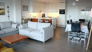 Un salon moderne comprenant un canapé, une table basse et un coin repas avec des chaises et une table.
