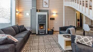 A living room with a fireplace, a sofa, a coffee table, and a staircase.
