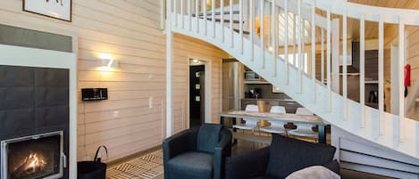 Et moderne interiør med pejs, trappe og spiseområde.