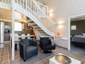 A modern interior with a staircase, seating area, and a kitchen. - Käränkkä by Interhome (Lieksa)