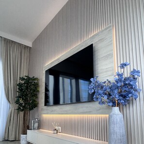 Enjoy a modern space with a flat-screen TV, console table, and beautiful flowers.