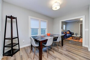 A dining area with a wooden table, gray chairs, and a dark wooden shelf. - Chic Spacious Downtown Retreat (Indianapolis)