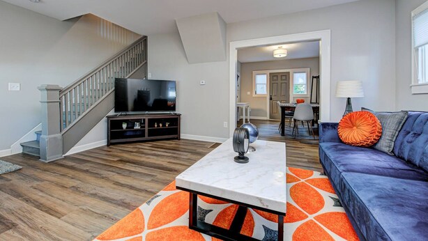 A living room with a TV, sofa, and coffee table. - Chic Spacious Downtown Retreat (Indianapolis)