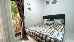 Ein Schlafzimmer mit Bett, Vorhängen, einem Fenster und Wanddekorationen.