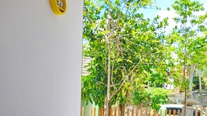 Eine Terrasse mit einem Holztisch und Stühlen, einem kleinen Topfpflanzen und einem Musterfußboden.