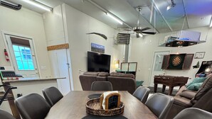 Ein Konferenzraum mit einem langen Holztisch, schwarzen Rundteppichen und einem gewebten Korb mit einem gerahmten Bild.