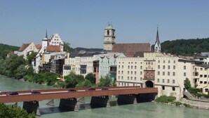 Un puente sobre un río, flanqueado por edificios, incluyendo una torre y una iglesia.
