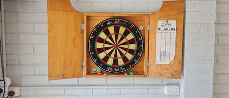 A dartboard mounted on a white brick wall.