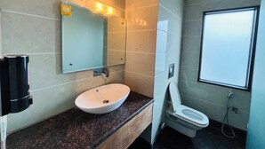 Un baño moderno con un espejo grande, un lavamanos y un inodoro.