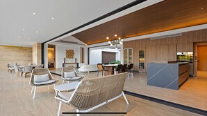 A spacious lobby with a reception desk, seating area with wicker chairs, and a modern kitchen in the background. - Srvittinivillas Flyvll/ Lux Spacious / Fam / Vacations / Casa de Campo Villas (La Romana)