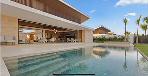A modern house with a swimming pool, outdoor seating, and a well-maintained garden. - Srvittinivillas Flyvll/ Lux Spacious / Fam / Vacations / Casa de Campo Villas (La Romana)