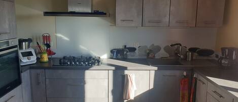 Un four, surface de cuisson, lave-vaisselle, vaisselle et ustensiles