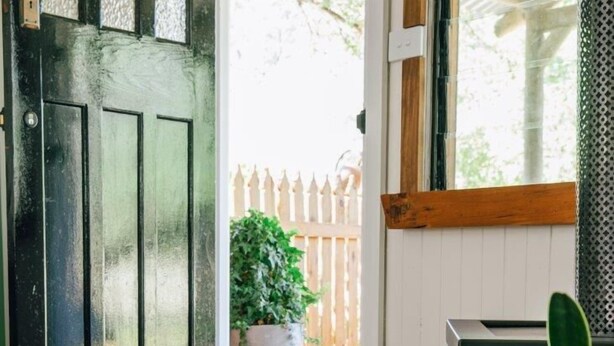 A wooden floor, a wicker basket with logs, a potted plant, and a black door. - Upon a Star - Welcoming you to the most charming holiday retreat, nestled in the picturesque village of Wandiligong, Victoria. (Wandiligong)