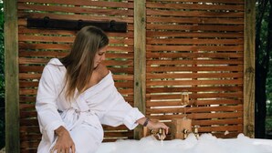 A person in a white robe sitting by a bathtub with a wooden backdrop. - Upon a Star - Welcoming you to the most charming holiday retreat, nestled in the picturesque village of Wandiligong, Victoria. (Wandiligong)