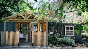 A wooden cabin with a sloped roof, a wooden fence, and a gravel driveway. - Upon a Star - Welcoming you to the most charming holiday retreat, nestled in the picturesque village of Wandiligong, Victoria. (Wandiligong)