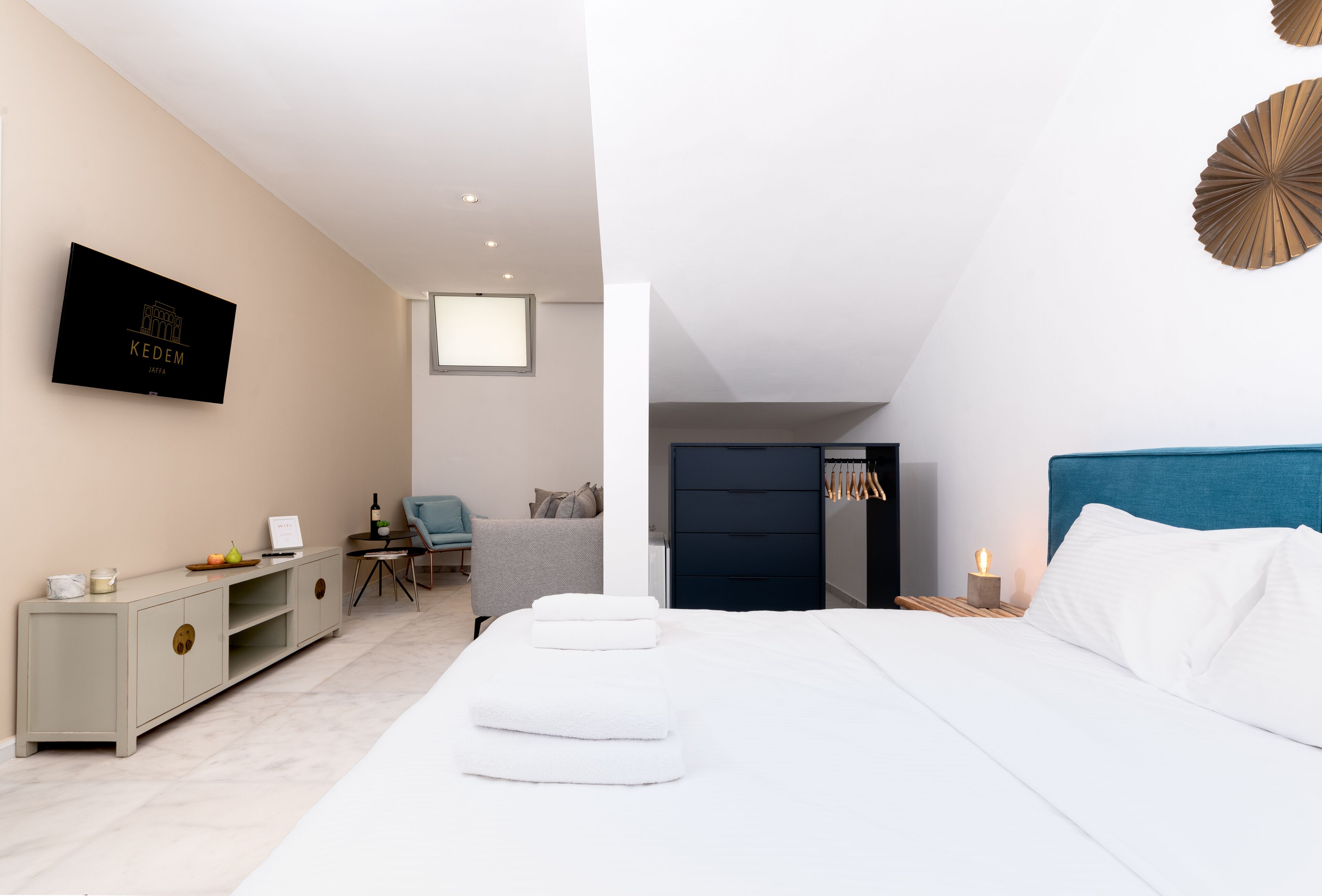 Une chambre d’hôtel moderne équipée d’un lit, d’un téléviseur fixé au mur, d’un bureau et d’une chaise.
