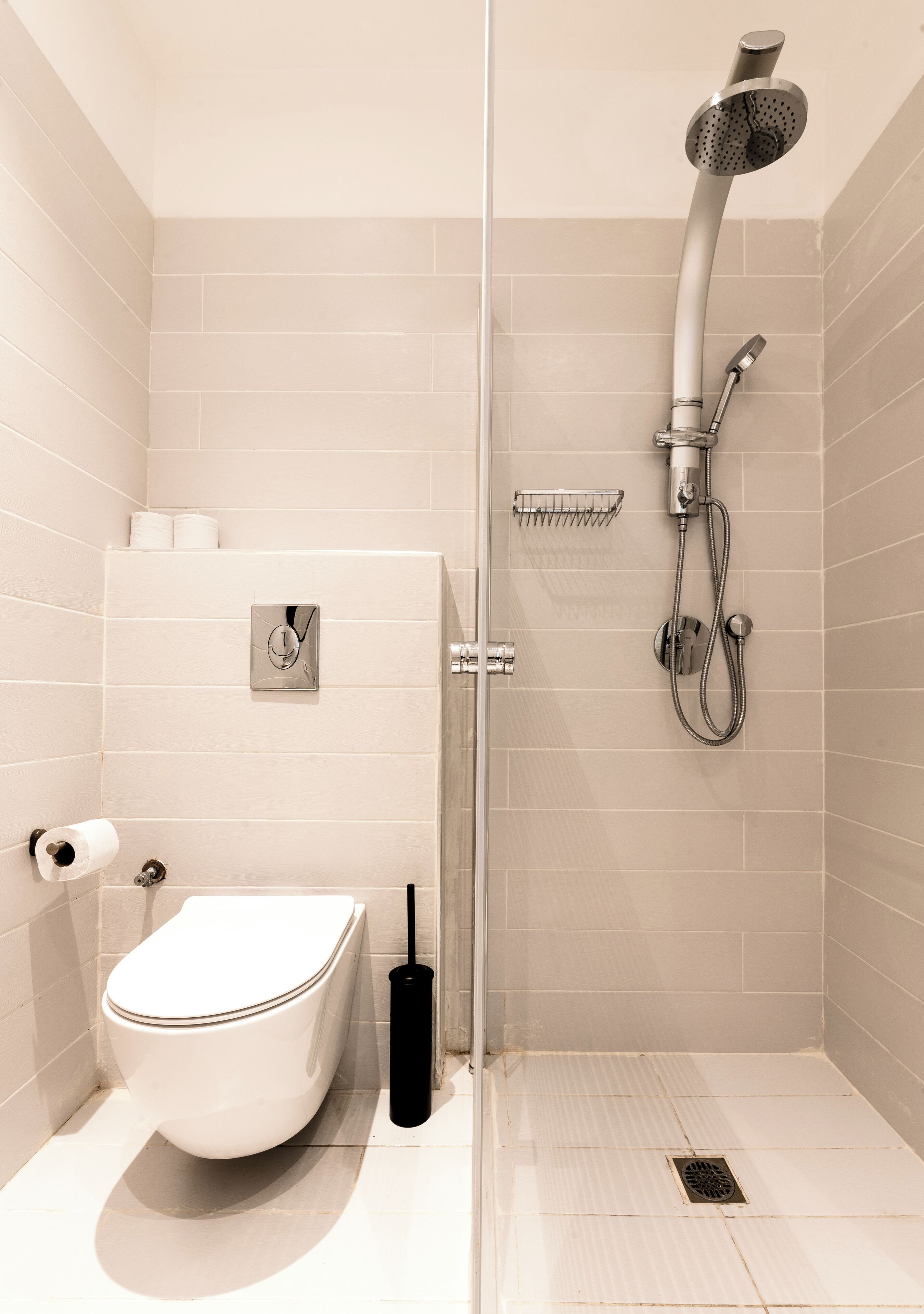 Un baño moderno con inodoro, ducha y secador de manos.