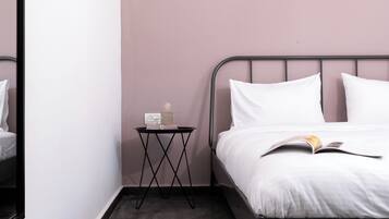 Une chambre à coucher avec un lit, une table de chevet, une petite lampe et un livre.