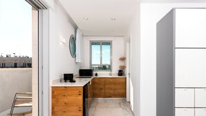 Une cuisine moderne avec des meubles en bois, un four à micro-ondes encastré et une fenêtre donnant sur la ville.