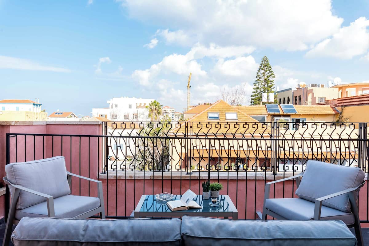A balcony with two chairs, a table, and a book.