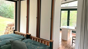 Un dormitorio con cama, escritorio y vistas al exterior.