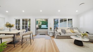 Una sala de estar moderna con comedor, un conjunto de sofás y una mesa de centro.