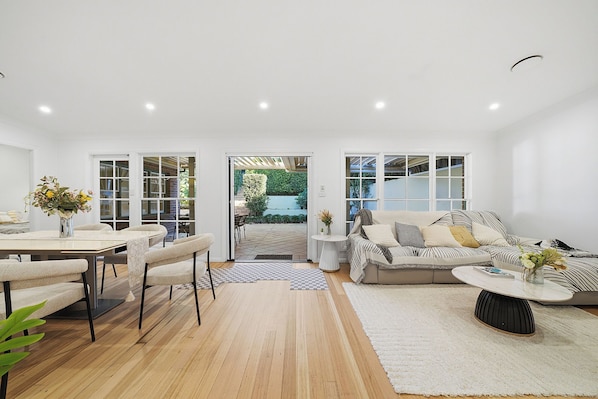 A modern living room with a dining area, a sofa set, and a coffee table.