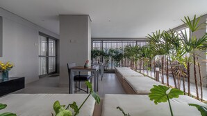 Et moderne hotelværelse med balkon, spiseplads og udsigt til haven.
