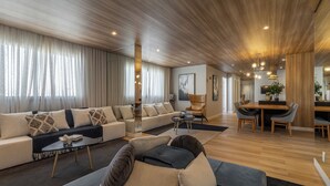 En moderne stue med sofa, sofabord og spiseområde med bord og stole.