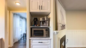 A kitchen with built-in appliances, including a coffee maker and a microwave, and a fireplace mantel. - Cameron's Peaceful Pines, King Bed! (Bayfield)