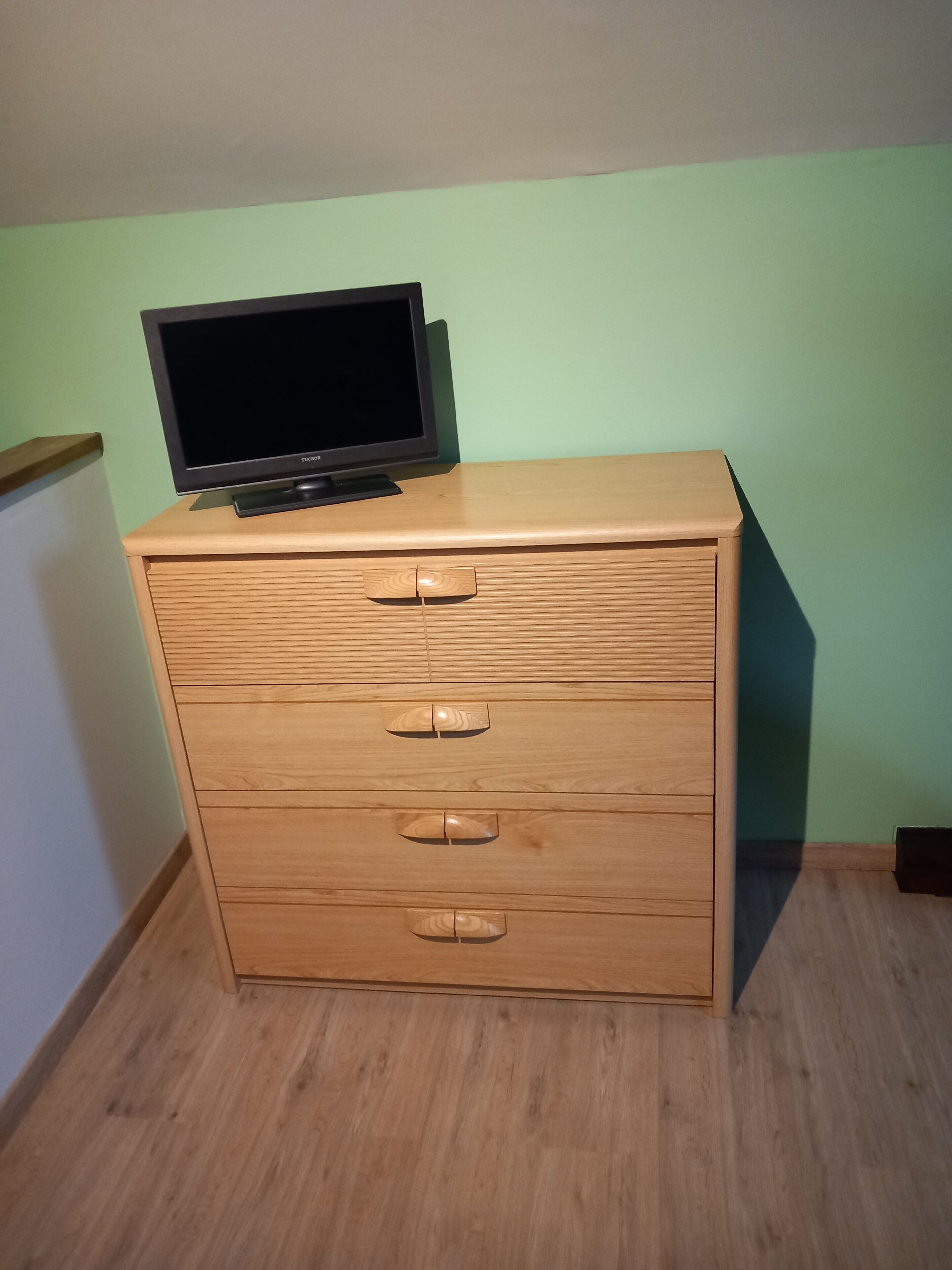 Un aparador de madera con un televisor encima.