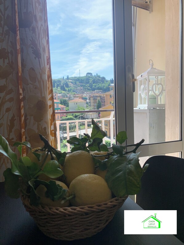 A wicker basket with lemons and a potted plant on a windowsill.