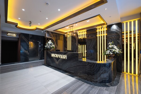 A reception area with a marble counter, a chandelier, and a sign that reads "RECEPTION". - Buke Hotel Bomonti (Istanbul)