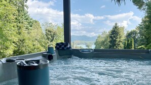 Un jacuzzi con vistas a un lago y árboles.