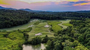 Vista aérea de un campo de golf con múltiples áreas de juego y un cuerpo de agua.
